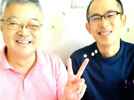 強い腰痛に悩んでいた患者さまと施術スタッフが並んで笑顔を見せている写真。回復後の安心した雰囲気が伝わる。