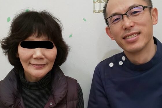 施術後に笑顔で並んで座る女性患者さんと施術者の様子。落ち着いた院内での記念写真