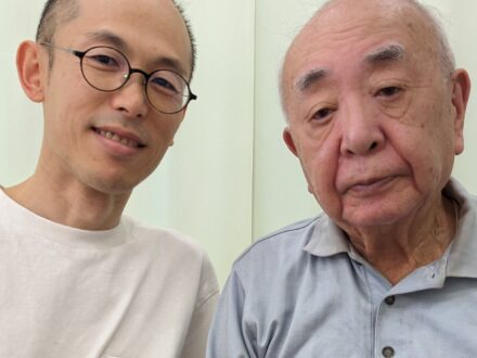 施術を担当した施術者と、高齢の男性患者が並んで写っている写真。室内で穏やかな表情をしている。