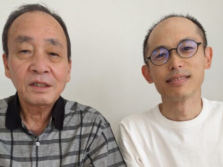 施術を終えた男性患者と施術者が並んで写っている写真。落ち着いた表情でカメラを見ている。