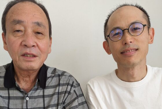 施術を終えた男性患者と施術者が並んで写っている写真。落ち着いた表情でカメラを見ている。