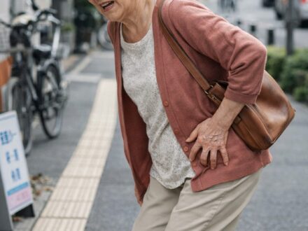 歩くとお尻からふくらはぎにかけて張りと痛みが出て、立ち止まりながら歩く高齢の女性